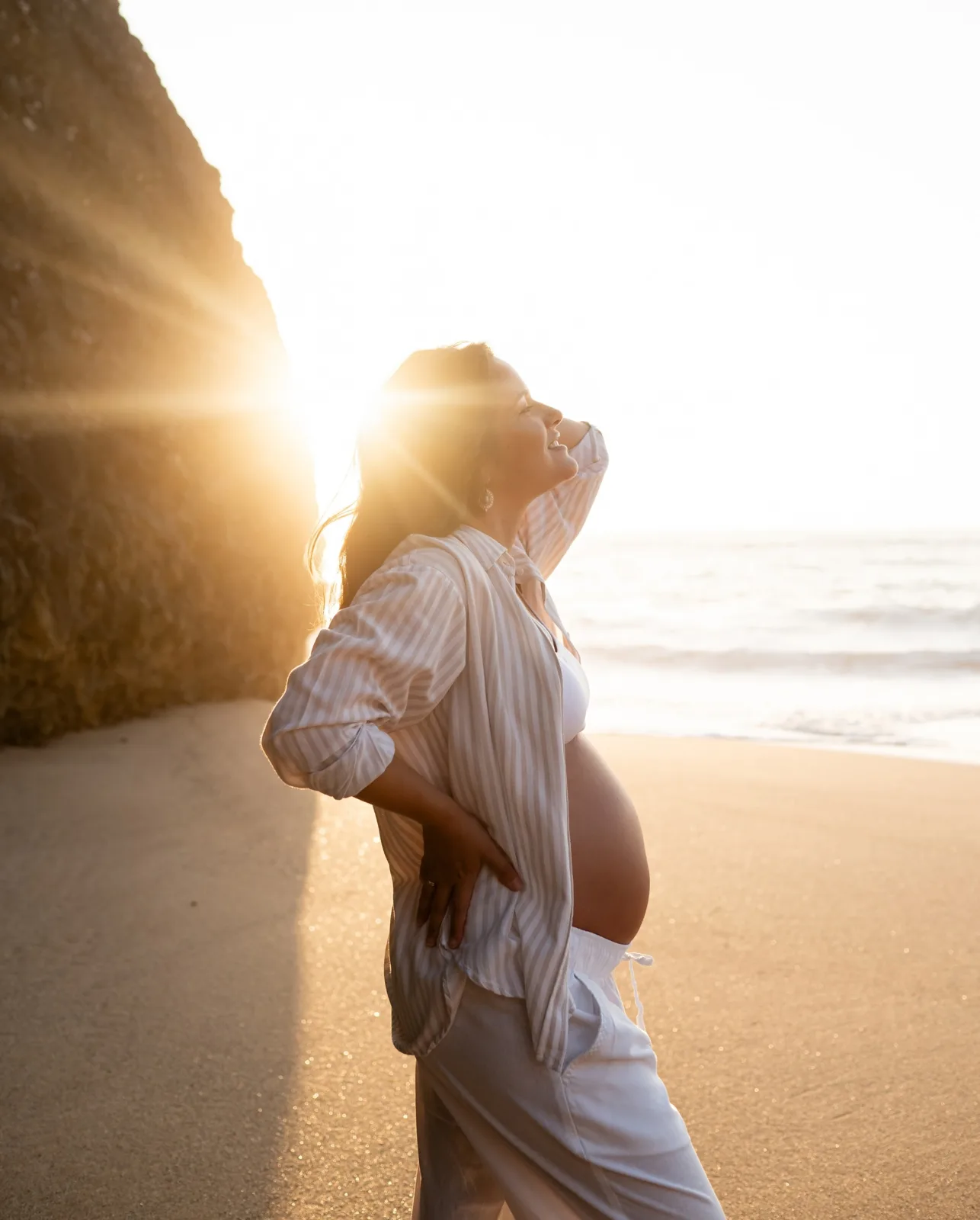 Grávida de camisa às riscas na praia
